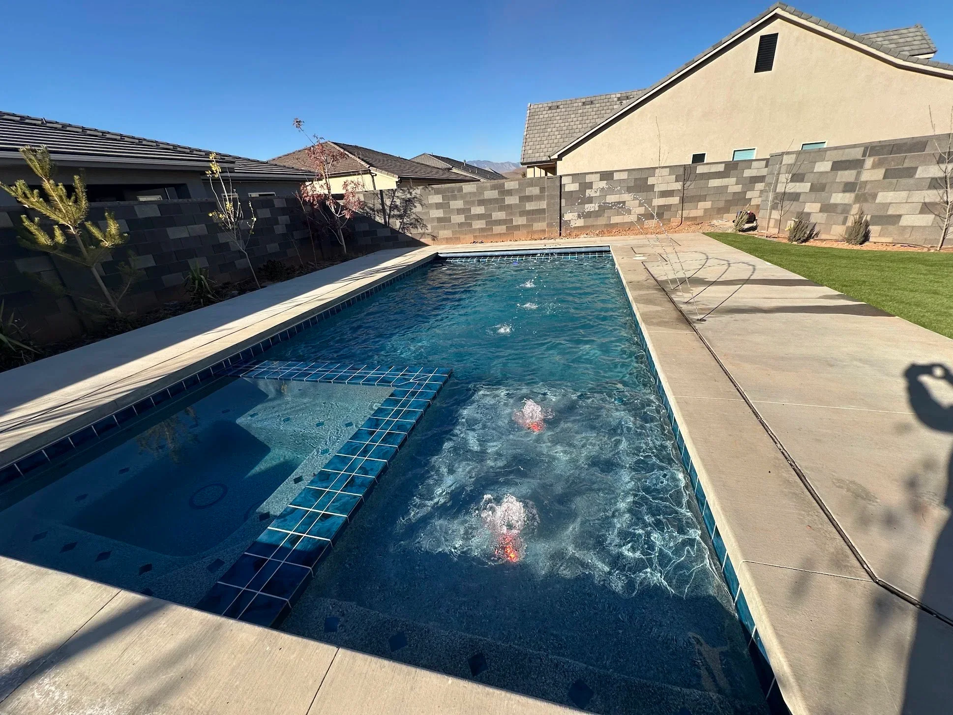 New-construction Aqua Desert pool with water jets and a wide concrete deck